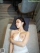 A woman laying on top of a bed next to a chair.