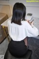 A woman sitting at a desk writing on a piece of paper.