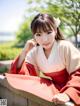 A woman in a red and white kimono sitting on a wall.